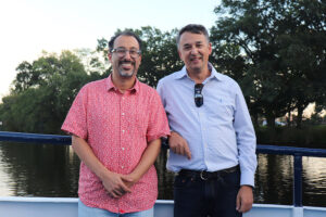 Image of CCSE Co-Directors Youssef Marzouk and Nicolas Hadjiconstantinou smiling with the Charles River and foliage in the background